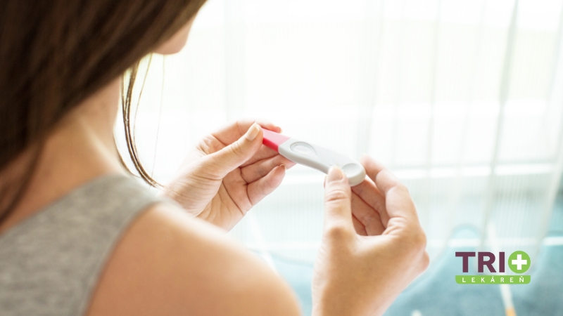 Žena držiaca tehotenský test v rukách, pripravená zistiť výsledok, na pozadí jemného denného svetla, čo symbolizuje rozhodovanie o správnom čase na vykonanie testu.